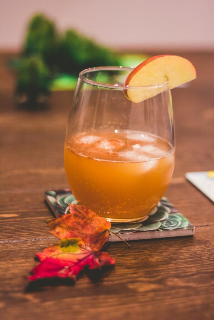 An inviting glass of cider made from apples and presented on an autumnal table