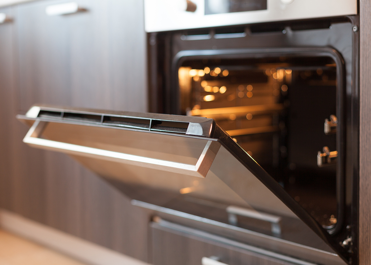 an empty oven with the door open and light glowing an empty oven with the door open and light glowing