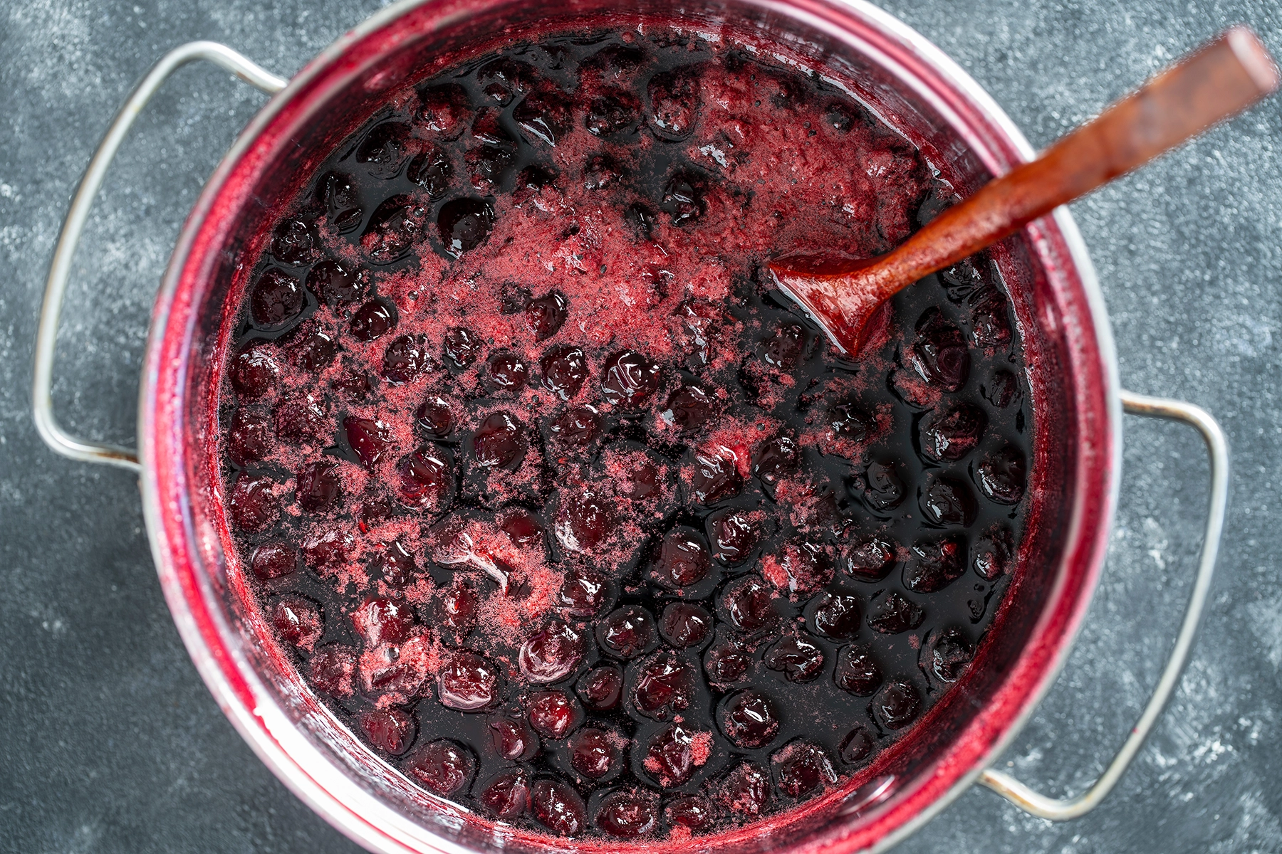 Cherry jam being heated inside a saucepan